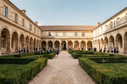 Vue d'ensemble d'un campus scolaire privé en Occitanie avec cour en pierre et élèves en uniforme